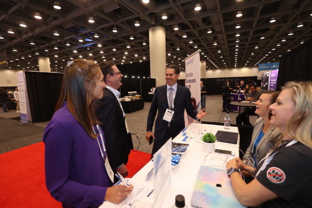 Crosschq reps (right) trade insights with fellow attendees on the expo floor before presenting their smart talent-vetting platform on the Innovation Stage.